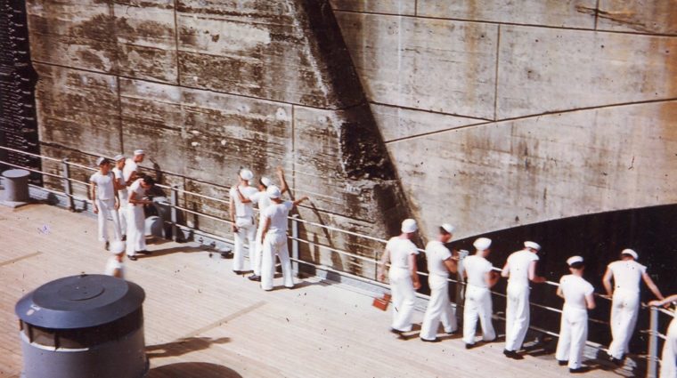 BB-62 sailors touching the walls of the Panama Canal as she passes through